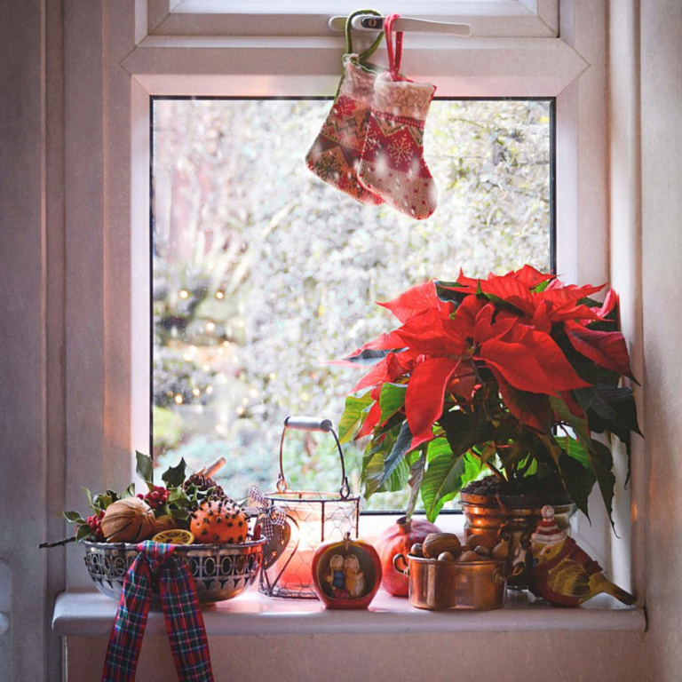 Home nook with holiday stockings hung above the window and decor on the sill below