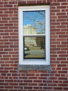 White double hung windows on brick home