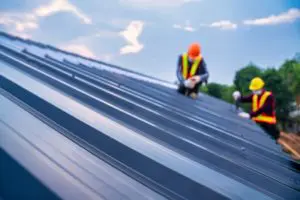 Roofer installing new roof metal sheet