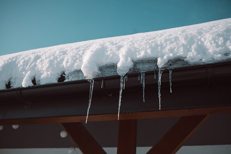 Icicles hang from a roof with ice dam issues