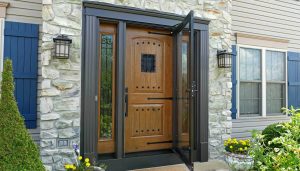 Black storm door installed over a light wood front door